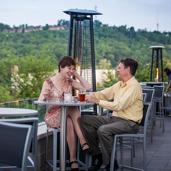 A couple having drinks outside on a terrace.