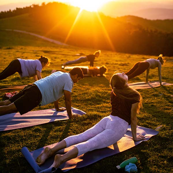 A group doing yoga at sunrise.