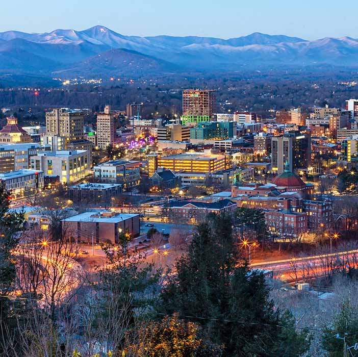 A beautiful arial photo of Asheville with mountains in the distance.