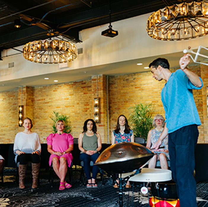 A group enjoying a music performance by a percusionist.