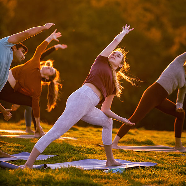 A group of people practicing yoga outdoors.