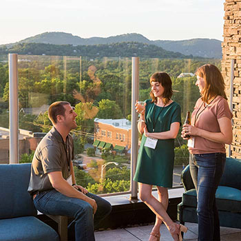 A group drinking at a bar on the roof of a hotel.