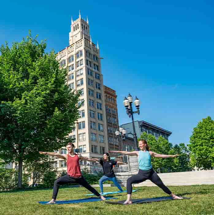 A group doing yoga in a park.