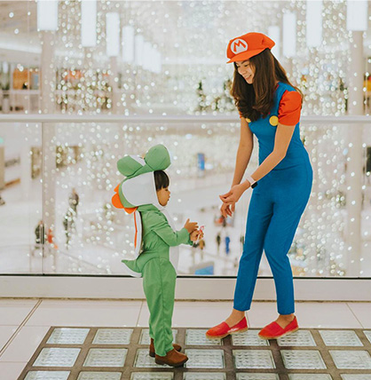A young girl and her mother dressed up as Super Mario Bros characters. 