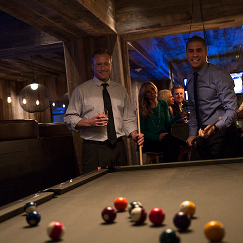 Men in business attire playing pool in a club