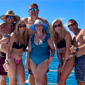 A group taking a photo on the front of a boat.