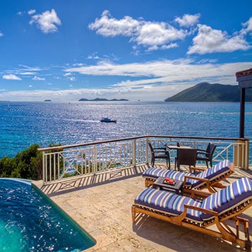 The deck of a resort room with ocean view.