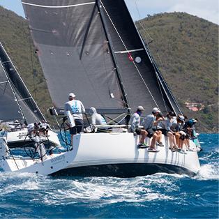 A sailboat with a group sitting on the side.