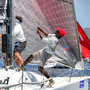 A man pulling on the rigging of a sailboat.