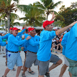 A sailboat team celebrating on the beach.