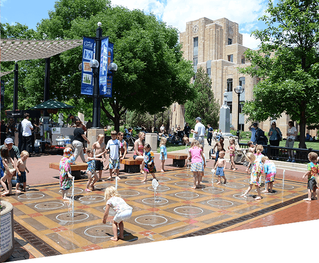 Kids playing in shooting fountains on Pearl Street