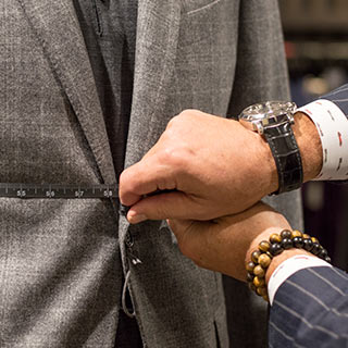 Tailor measuring a suit. 