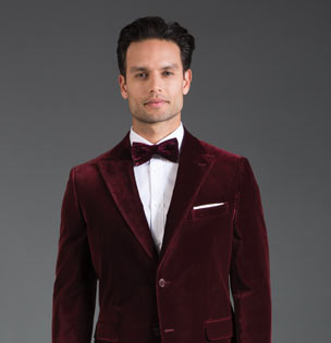 Man in maroon velvet tuxedo and bowtie. 