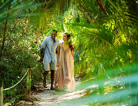 Couple walking a trail in the woods.