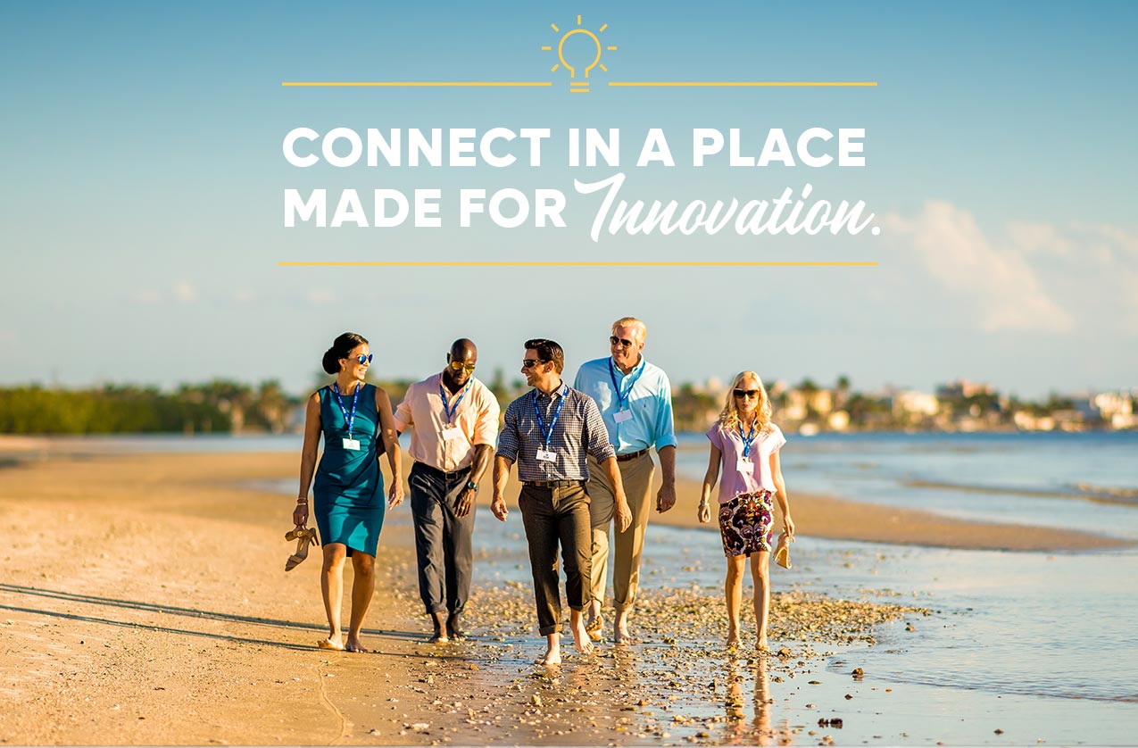Connect in a Place Made for Innovation. - A group of people in business casual clothes walking on the beach. 