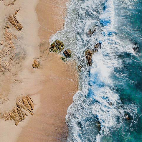 Water rolling over the beach rocks.