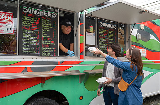 Two people visiting a food truck.