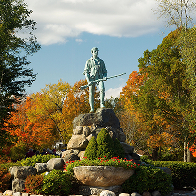 A statue surrounded by fall foliage in New England. Click here to book.