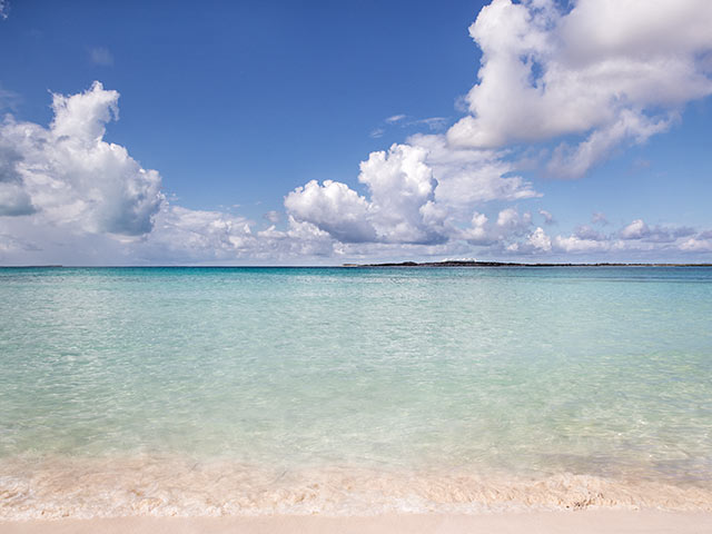 A white-sand Caribbean beach leading to turquoise water. Click here to book.