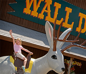 Little girl riding a fake deer