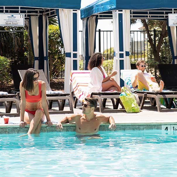 People out relaxing by a pool. 