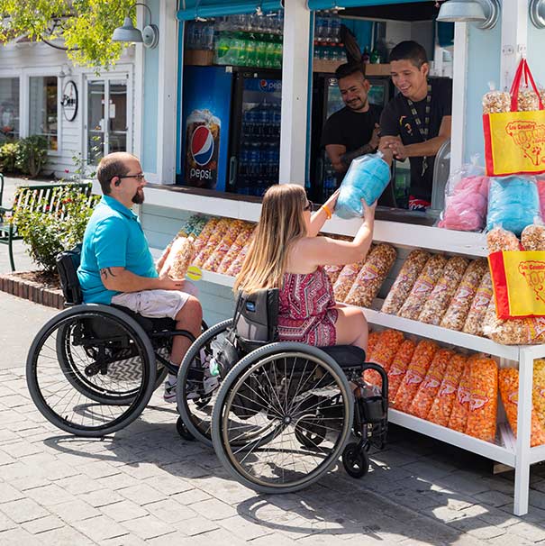 A couple buying cotton candy from a street vendor. 