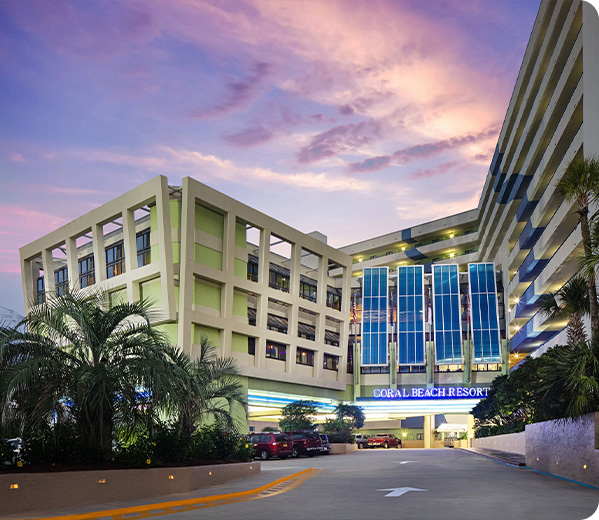 Exterior of resort, driving up at sunset.