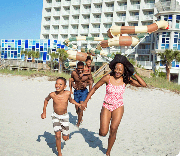 A family running on the beach.
