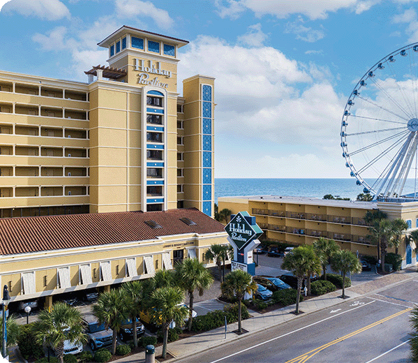 Holiday Inn exterior a ferris wheel and the ocean in the background.