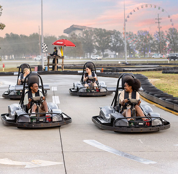 Kids riding on go-carts on a course.