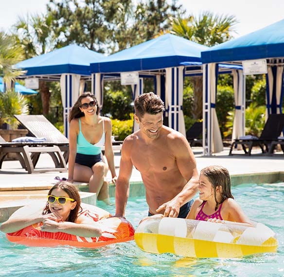 A family hanging out in a pool together.