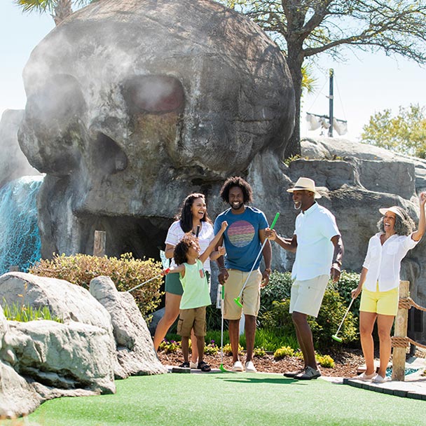 Family playing miniature golf.